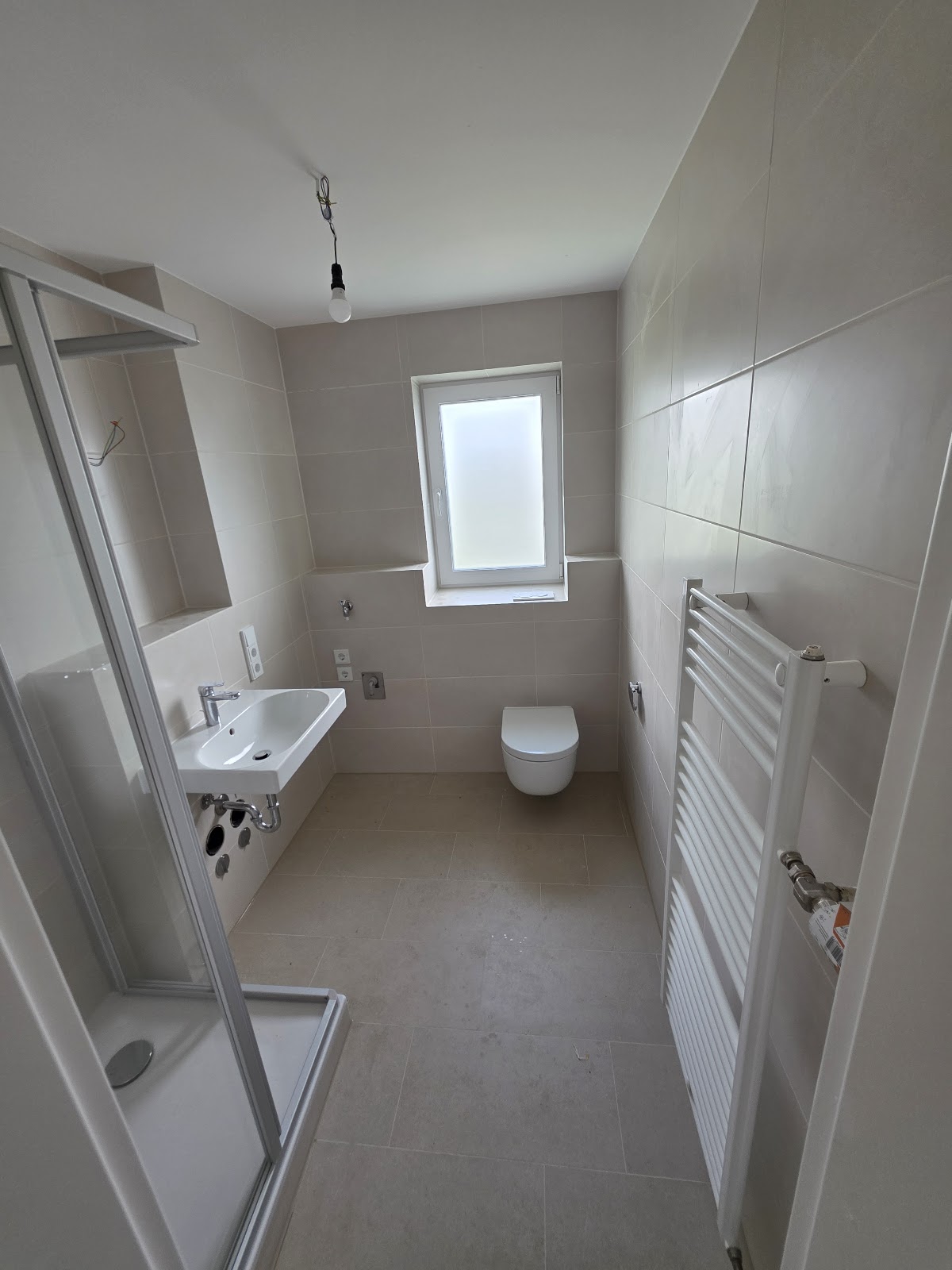 Neu saniertes Badezimmer in Welden mit Dusche, Waschbecken und Wand-WC in warmen Beigetönen
