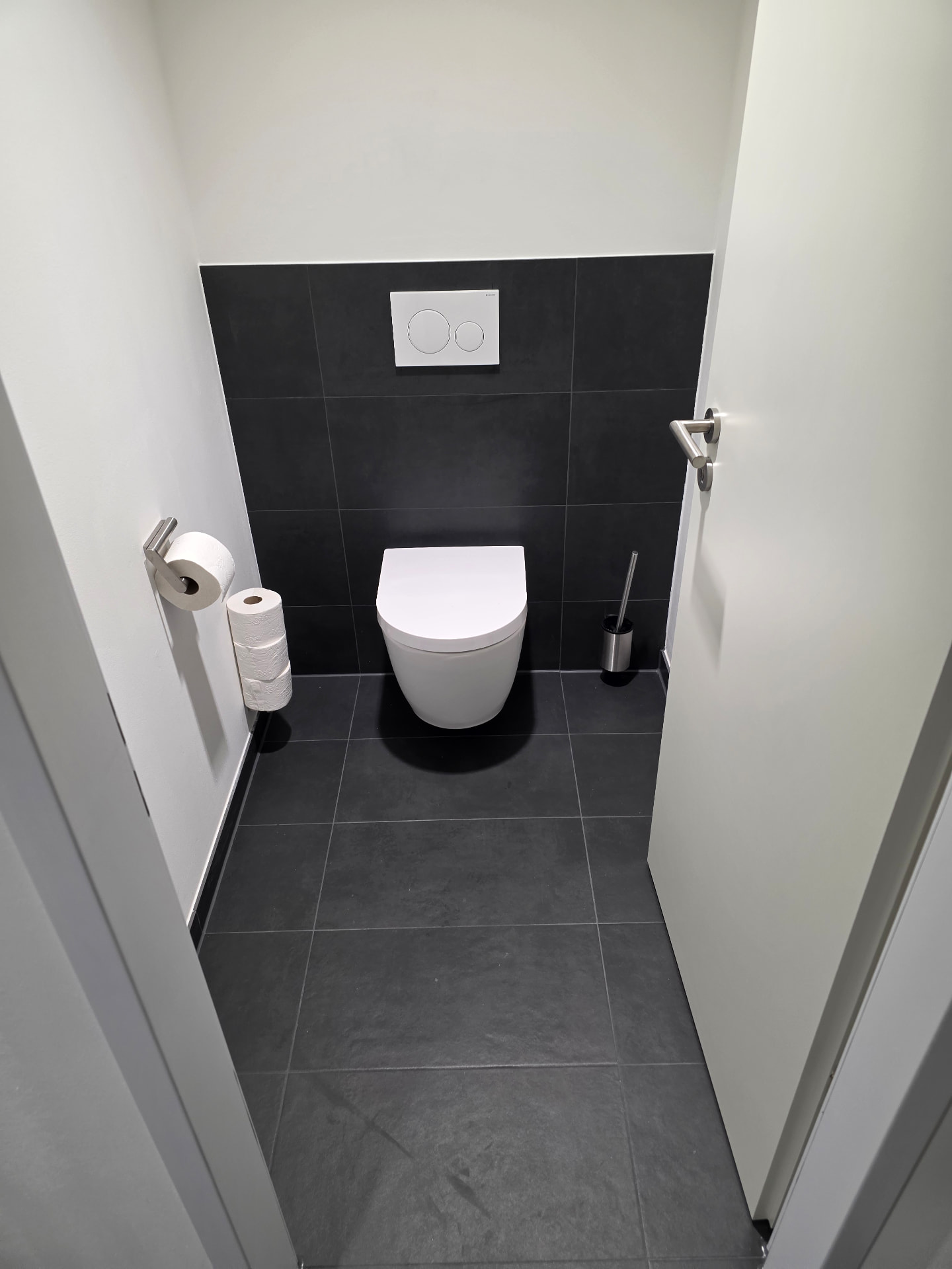 Wandhängendes WC mit anthrazitfarbenen Fliesen in der WC-Anlage bei Rohde & Schwarz in München